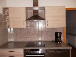 cocina con armarios de madera y horno con fogones en Ferienwohnung Jürges, en Northeim