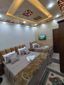 Habitación con 2 camas y TV en el techo. en Petra downtown house, en Wadi Musa