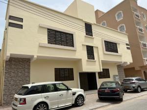 une voiture blanche garée devant un bâtiment dans l'établissement Red-3 - New Salalah, à Salalah