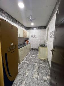 une cuisine vide avec une porte dans une pièce dans l'établissement Red-3 - New Salalah, à Salalah