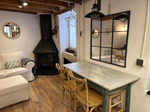 a living room with a table and chairs and a fireplace at Casa MARcerdanya in Puigcerdà