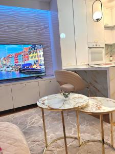 ein Wohnzimmer mit Tisch und Fernseher in der Unterkunft Coral in Sarajevo