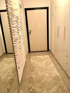 einen Flur mit Tür in einem Zimmer mit Teppich in der Unterkunft Coral in Sarajevo