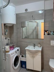 ein Badezimmer mit Waschmaschine und Waschbecken in der Unterkunft Coral in Sarajevo