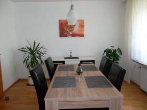 Ferienwohnung Jürges في نورتهايم: غرفة طعام مع طاولة وكراسي خشبية