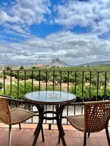 a table and chairs on a balcony with a view at Los Dólmenes in Antequera