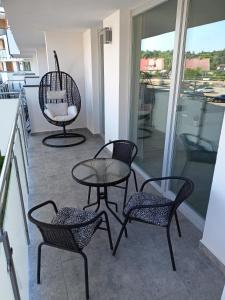 a patio with two chairs and a table and chairs at Apartament Baltic Garden Sztutowo in Sztutowo