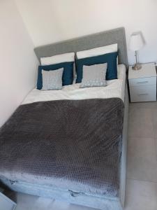 a bedroom with a large bed with blue pillows at Apartament Baltic Garden Sztutowo in Sztutowo
