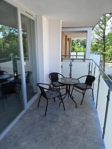 a patio with a table and chairs on a balcony at Apartament Baltic Garden Sztutowo in Sztutowo