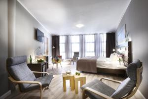 a hotel room with a bed and a living room at Hotel Kiel by Golden Tulip in Kiel