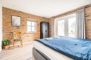 a bedroom with a large bed and a brick wall at Gastsuite Foar elkoar Hilaard. in Hijlaard