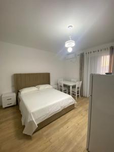 a bedroom with a white bed and a table at Sempaola Borsh Apartments in Borsh