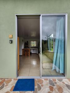 une porte coulissante en verre menant à un salon avec une table. dans l'établissement Selvática del Toro, à Bajos del Toro