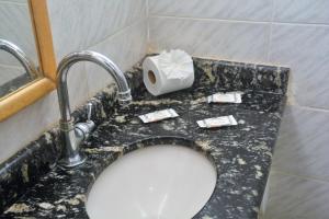 a bathroom counter with a sink and a toilet at Pousada Mare Blue in Búzios