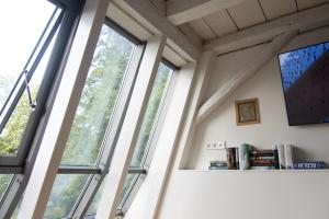 una habitación con ventanas y libros en un estante en villaflora Gästehaus en Riedlingen