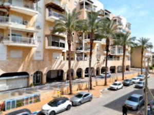 a street with cars parked in front of a building at Your home in Acre from Shneider Apartments in Acre