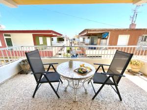 eine Terrasse mit einem Tisch und 2 Stühlen auf einem Balkon in der Unterkunft Apartamento OLIVA PLAYA - PAU PI in Oliva