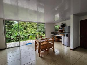 eine Küche mit einem Tisch und Stühlen sowie einem großen Fenster in der Unterkunft Selvática del Toro in Bajos del Toro