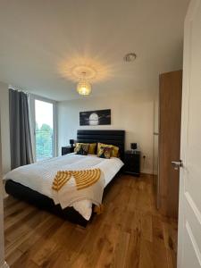 ein Schlafzimmer mit einem großen Bett und Holzboden in der Unterkunft Uxbridge Apartment in Uxbridge