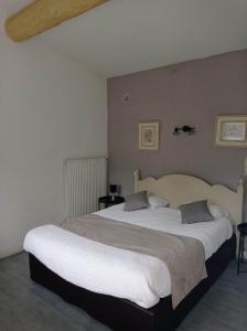 a bedroom with a large bed with white sheets at Logis Hotel Restaurant la Corniche des Cevennes in Saint-Jean-du-Gard