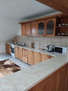 a kitchen with wooden cabinets and a marble counter top at Apartmán Tatiana in Smižany
