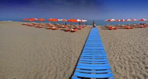 a long line of blue beach chairs and umbrellas at Palladion in Adelianos Kampos