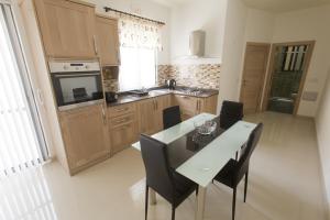a kitchen with a table and chairs in a kitchen at Waterside Apartments in Marsalforn