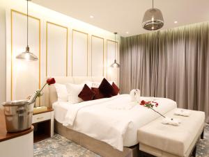 ein Schlafzimmer mit einem großen weißen Bett mit zwei Hockern in der Unterkunft وايت مون للاجنحة الفندقية الضيافة in Chamis Muschait