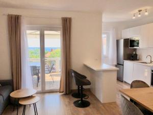 een keuken en een woonkamer met uitzicht op de oceaan bij Apartments Kankul in Krk