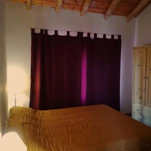 1 dormitorio con cama y cortina negra en Cabañas Vistas Andinas en Valle Grande