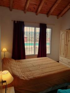 1 dormitorio con cama grande y ventana grande en Cabañas Vistas Andinas en Valle Grande