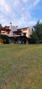 a large building with a grass field in front of it at nikol villa elani in Siviri