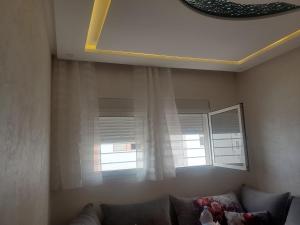 ein Wohnzimmer mit einem Sofa und einem Fenster in der Unterkunft Joli appartement in Agadir
