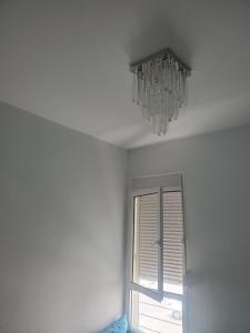 a chandelier hanging from a ceiling next to a window at Joli appartement in Agadir