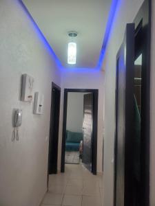 einen Flur mit blauen Lichtern an der Decke in der Unterkunft Joli appartement in Agadir