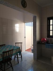 a kitchen with a table and a table and a door at Casa Martim de Sá in Caraguatatuba