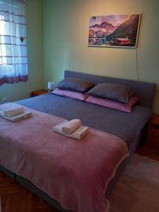 a bedroom with two beds with towels on them at Apartman 4 in Rijeka