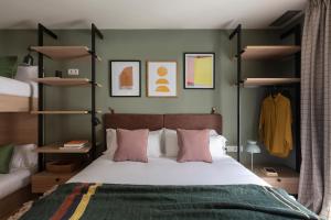 a bedroom with a large bed with pink pillows at TOC Hotel Las Ramblas in Barcelona
