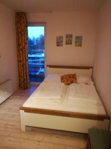 ウッカーミュンデにあるFerienwohnung-Hafenblick-Ueckermuende-Stettiner-Haff-Ostseeの大きな窓付きの客室のベッド1台分です。