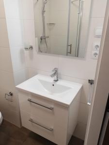 a white bathroom with a sink and a mirror at Ferienwohnung-Hafenblick-Ueckermuende-Stettiner-Haff-Ostsee in Ueckermünde