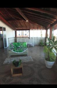 uma sala de estar com sofás e vasos de plantas em Hostel Ariel Beach Pousada em Mongaguá