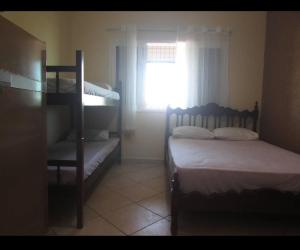 1 dormitorio con 2 literas y ventana en Hostel Ariel Beach Pousada en Mongaguá