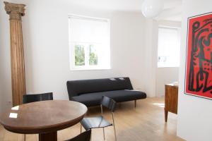 - un salon avec un canapé noir et une table dans l'établissement villaflora Gästehaus, à Riedlingen
