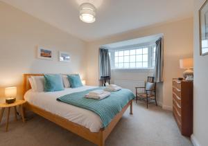um quarto com uma cama grande e almofadas azuis em Marlon House em Southwold