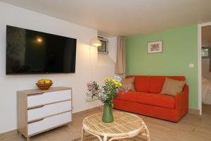 a living room with a red couch and a vase of flowers at L'Eucalyptus avec Parking & Wifi in Quincy-Voisins