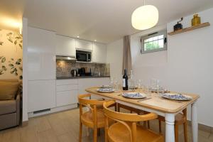 a dining room with a table and chairs and a kitchen at L'Eucalyptus avec Parking & Wifi in Quincy-Voisins