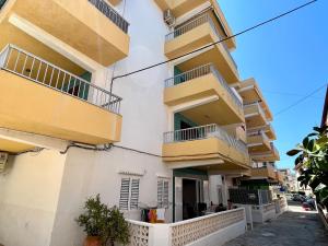 ein Gebäude mit gelben Balkonen auf einer Straße in der Unterkunft Apartamento OLIVA PLAYA - PAU PI in Oliva