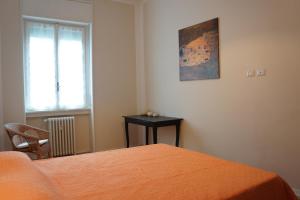 ミラノにあるApartment Papiniano 38のベッドルーム1室(ベッド1台、テーブル、窓付)