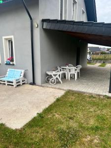 a patio with a table and chairs next to a building at Apartament Wrzosowa in Kudowa-Zdrój