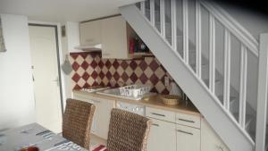 a kitchen with a staircase and a table and chairs at PLEINE VUE MER PISCINE duplex parking privé fibre wifi plage 6 minutes a pied st pierre la mer in Fleury